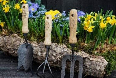 Haveredskaber foran forårsblomster. Klargøring af haveredskaber er ét af flere gode råd til havearbejde i marts fra Hobby Haven
